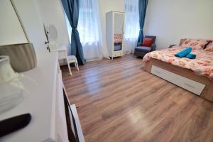 a bedroom with a bed and a wooden floor at FLH - Best Location for Good Vibes - City Center in Sibiu