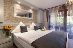 ein Schlafzimmer mit großem Bett und Fenster in der Unterkunft Hotel Petra in Baiersbronn
