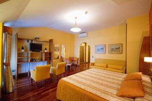Hotel Los 5 Pinos في مدريد: غرفة نوم مع سرير وغرفة معيشة