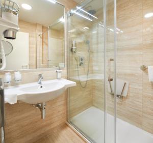 een badkamer met een wastafel en een douche bij OREA Spa Hotel Cristal in Mariánské Lázně