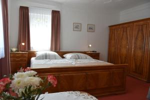 1 dormitorio con cama grande de madera y ventana en Feriendomizil Frey, en Sitzendorf