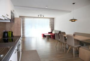 a kitchen and living room with a table and chairs at Ferienwohnungen Marmot in Kappl