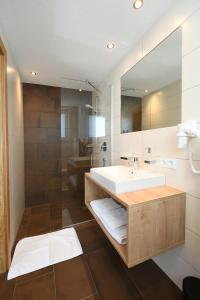 a bathroom with a sink and a mirror at Ferienwohnungen Marmot in Kappl