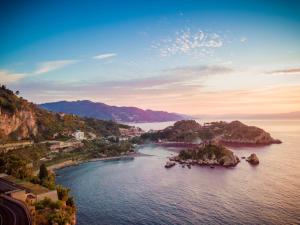 an island in a body of water with mountains in the background at Taormina Panoramic Hotel in Taormina