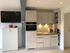 a kitchen with white cabinets and a refrigerator at Ferienanlage Vorauf - be lucky in Siegsdorf