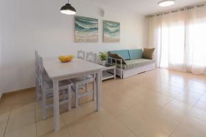 un salon avec une table et un canapé dans l'établissement Zeus Guardamar Seaview, à Miami Platja