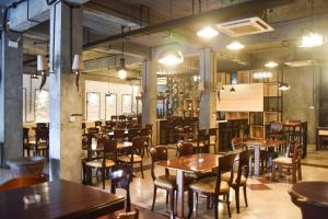 a restaurant with wooden tables and chairs in a room at RedDoorz near Kampung Warna Warni in Malang