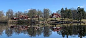 een weerspiegeling van huizen in het water van een meer bij Trollebo Säteri in Vetlanda