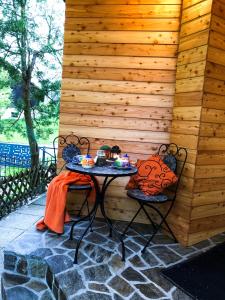 un tavolo e sedie di fronte a una parete in legno di Korošec Apartments and Wellness Centre a Mozirje