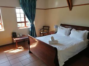 sypialnia z łóżkiem z wypchanym zwierzakiem w obiekcie The Woodsman Bed and Breakfast w mieście Sabie