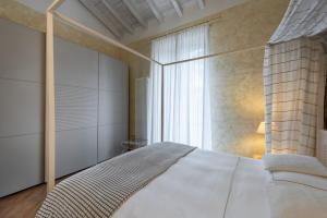 a bedroom with a white bed and a window at Hotel Mastino in Verona