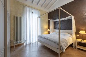 a bedroom with a canopy bed and a large window at Hotel Mastino in Verona