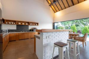 a kitchen with a counter and a table with chairs at Luxury Villa Dore in Jimbaran
