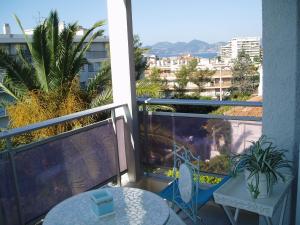 a balcony with a table and chairs and a view of a city at Eden Residence in Cannes