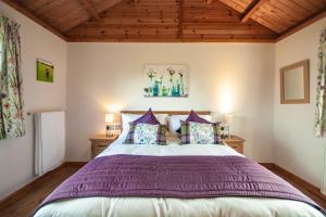 a bedroom with a large bed with purple pillows at Osprey lodge in Elgin