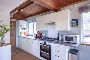 a kitchen with white cabinets and a microwave at Osprey lodge in Elgin
