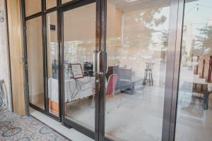 メダンにあるRedDoorz near Ringroad City Walks Medanのテーブル付きの客室内のガラスの引き戸