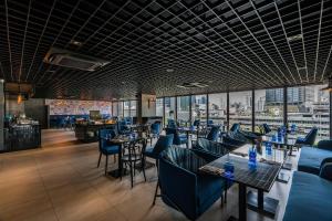 a restaurant with blue chairs and tables and windows at The Key Premier Hotel Sukhumvit Bangkok in Bangkok