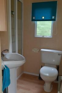 a bathroom with a white toilet and a sink at Letniaczki ABI in Rydzewo +57 photos