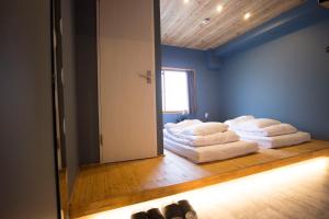 2 Betten in einem Zimmer mit Spiegel in der Unterkunft SHARIN in Kanazawa