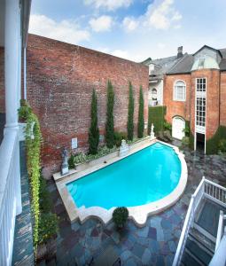 a swimming pool in front of a brick building at Chateau Hotel in New Orleans