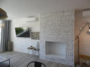 a living room with a white brick fireplace at AlquilaEasy Windsor in Benalmádena