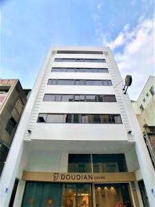 a tall white building with the number dublin on it at Doudian DDiNN Hotel in Taichung