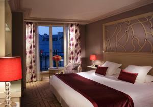 um quarto de hotel com uma cama grande e uma janela em Rochester Champs Elysees em Paris