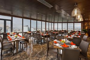 a restaurant with tables and chairs and large windows at Grand Sunrise Boutique Hotel in Da Nang