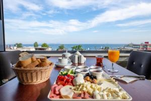 einen Tisch mit einem Teller Essen und Meerblick in der Unterkunft Golden Sand Hotel in Istanbul