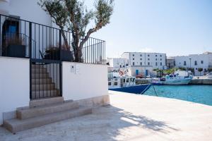 a building with stairs and a tree next to the water at La casa di Alice in Monopoli
