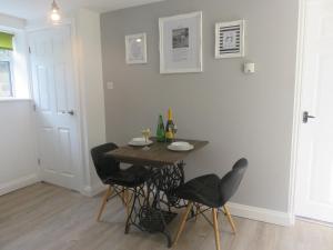 a dining room with a table and two chairs at Esk Cottage - Cyanacottages in Whitby +8 photos