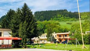 a park with a playground with trees and houses at Rodinný RETRO domček in Dolný Kubín