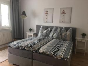 een bed in een slaapkamer met twee schilderijen aan de muur bij Ferienwohnung Ostseetraum in Rostock