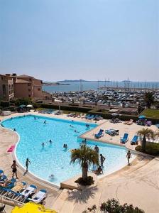 - une grande piscine avec des personnes à l'eau dans l'établissement Vue sur la mer, plage à 50m, à Six-Fours-les-Plages