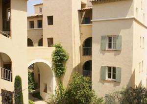 a large apartment building with a tree in front of it at Vue sur la mer, plage à 50m in Six-Fours-les-Plages