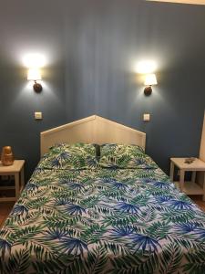 a bed in a bedroom with two lights on the wall at Vue sur la mer, plage à 50m in Six-Fours-les-Plages