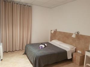 a bedroom with a bed with a stuffed animal on it at Hostal Martinval in Barcelona