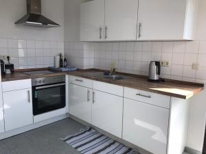 uma cozinha com armários brancos e um lavatório em Moderne 3 Zimmer Wohnung in Heiligenhaus em Heiligenhaus