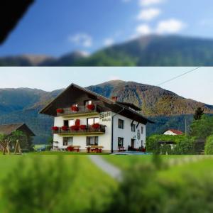 un edificio blanco con sillas rojas frente a una montaña en Guesthouse Schoba Typ D, en Kirchbach
