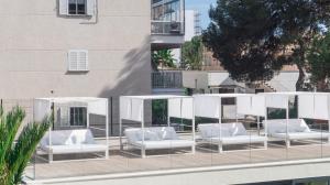 a group of white lounge chairs on a balcony at Hotel Paradiso Garden in Playa de Palma