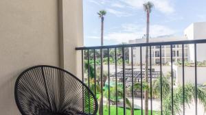 a chair sitting on a balcony with palm trees at Hotel Paradiso Garden in Playa de Palma
