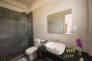 a bathroom with a sink and a toilet and a mirror at Filoxenia Hotel in Volos
