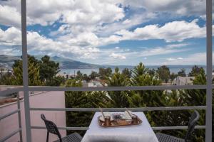 a table on a balcony with a view of the water at Filoxenia Hotel in Volos