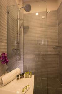 a bathroom with a glass shower and a sink at Filoxenia Hotel in Volos