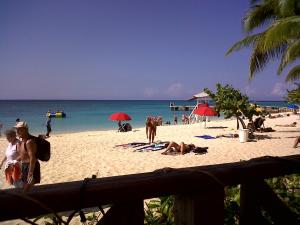 a group of people on a beach with the ocean at Ocean View Montego Bay Apartment in Montego Bay