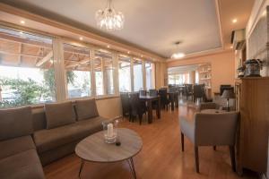 a living room with a couch and tables and chairs at Filoxenia Hotel in Volos