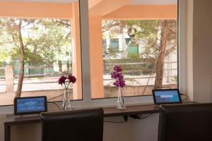 a desk with three laptops on it with two windows at Filoxenia Hotel in Volos
