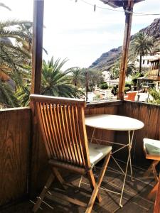 una silla y una mesa en un balcón con palmeras en Torre Azul, en Valle Gran Rey