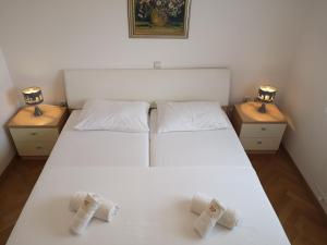 a bedroom with a white bed with two night stands at Spacious apartment on a great location -Apartment Kuhta in Biograd na Moru